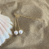 Gold Threaders with Round Pearls resting on sand