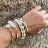 14k gold-filled baroque pearl bracelet by RAW Copenhagen, shown stacked with other freshwater pearl and hematite 
bracelets.