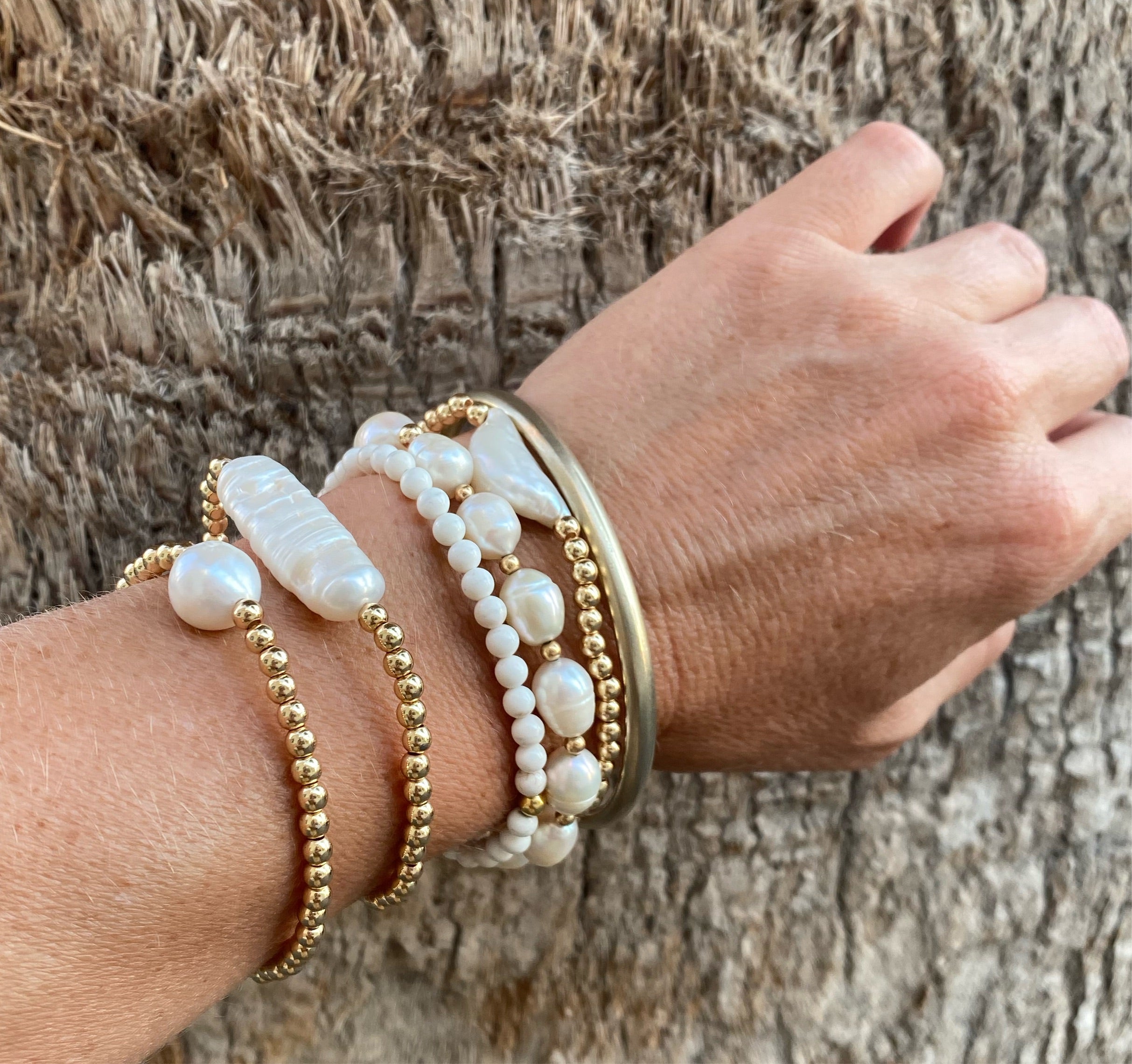 14k gold-filled baroque pearl bracelet by RAW Copenhagen, shown stacked with other freshwater pearl and hematite 
bracelets.